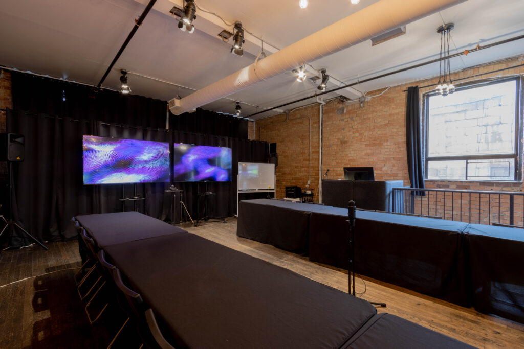 StartWell's Offsite Venue features two massive screens for turn-key presentations plus an AV booth with mac computer - so you don't need to connect your own computer to present, and video conferencing is always on